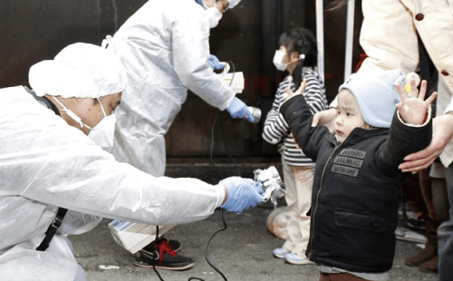 Officials in protective gear check for signs of radiation on children who are from the evacuation area near the Fukushima Daini nuclear plant  Photo: REUTERS/Kim Kyung-Hoon